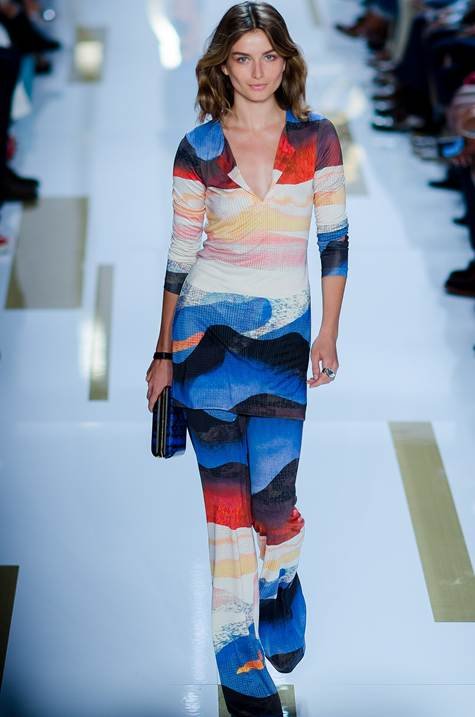 Alt text: Loud luxury energy on a New York runway as a model walks in a bold printed dress