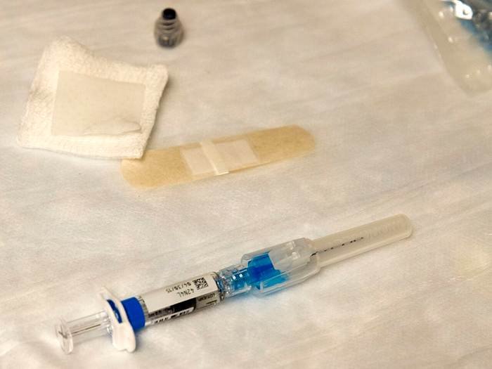 mRNA flu vaccine dose and syringe laid out before a seasonal influenza vaccination