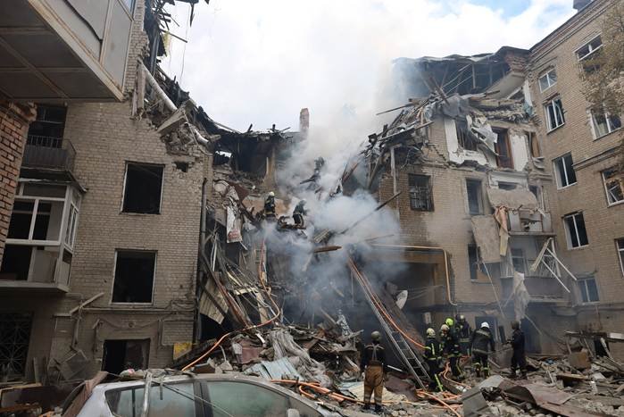 Russian strikes on Ukraine shown by firefighters at a damaged apartment block after Russian shelling