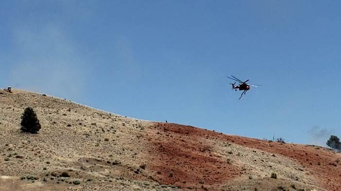 Greece wildfire helicopter makes a water drop over a burning hillside
